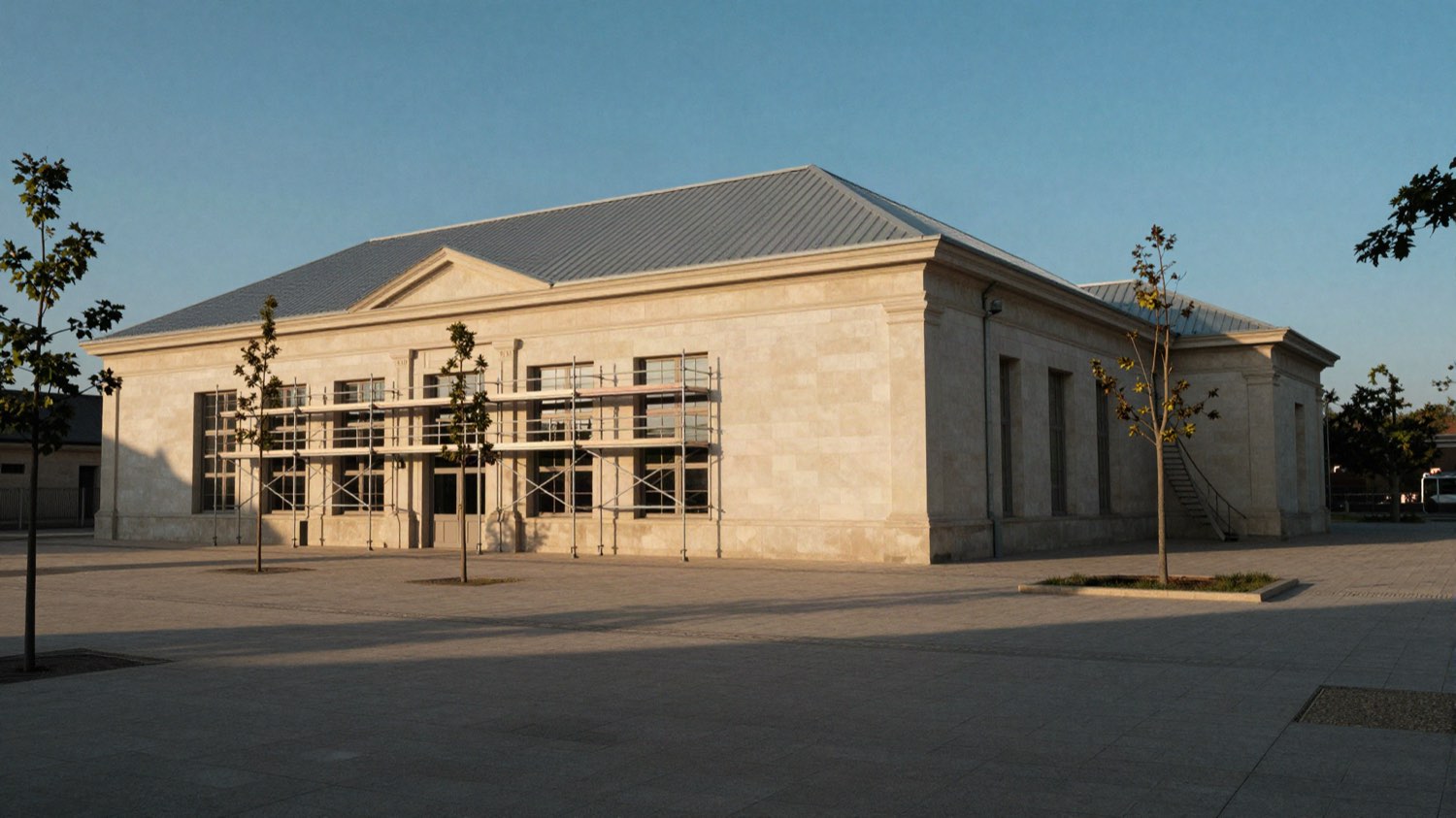 Un gymnase communal fraîchement rénové, échafaudages démontés, au soleil couchant